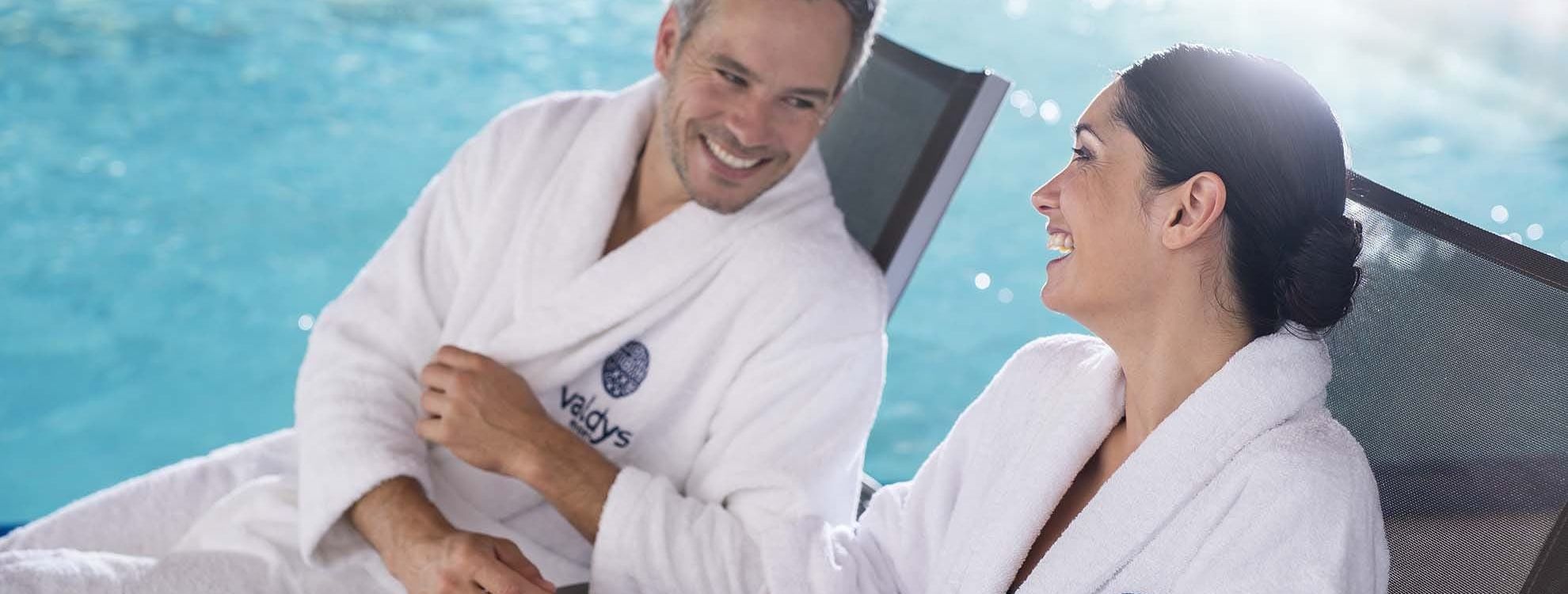Couple sur des transats au bord d'une piscine thalasso