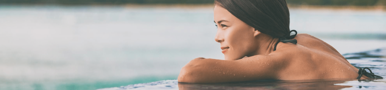 femme au bord d'une piscine avec vue mer