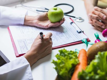 Main d'une personne réalisant une consultation diététique