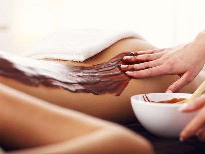 Application d'un enveloppement au chocolat sur le dos d'une femme