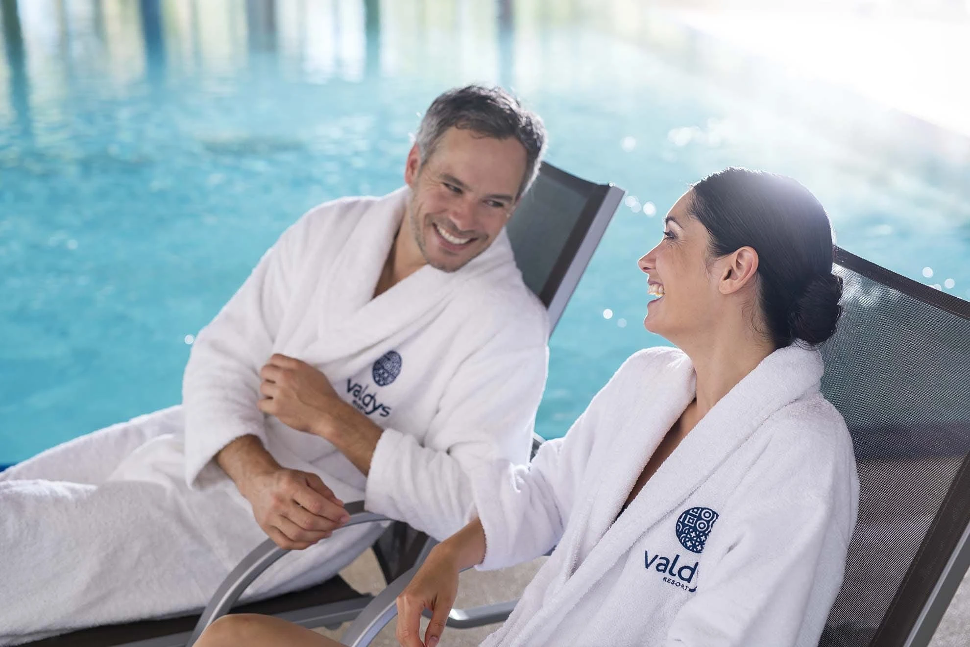 Couple sur des transats au bord d'une piscine thalasso