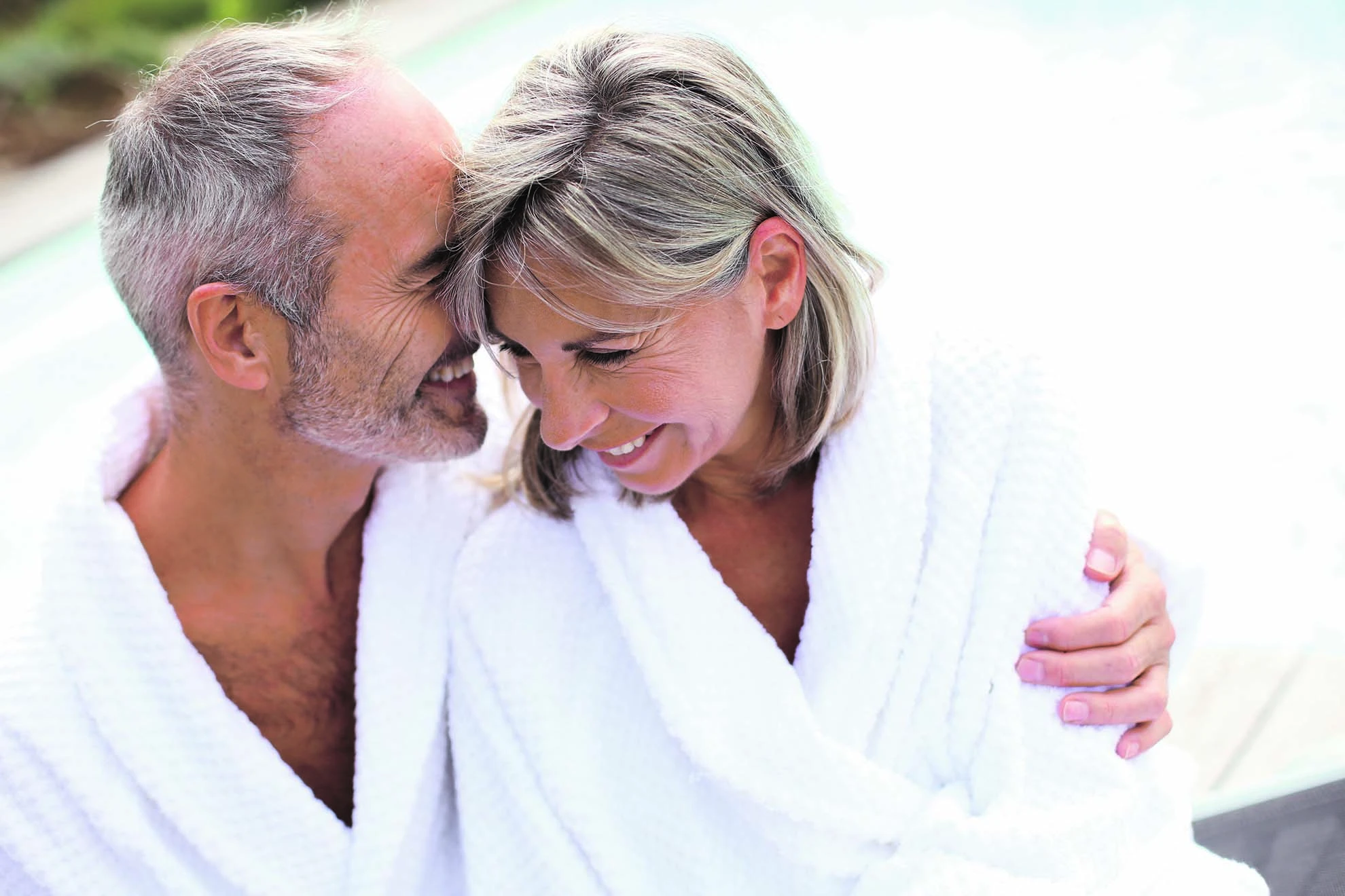 Couple détendu en peignoir à coté d'une piscine Thalasso