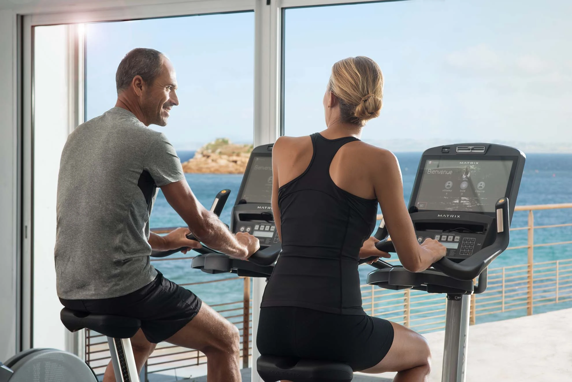 une personne avec son coach sportif sur vélo elliptique